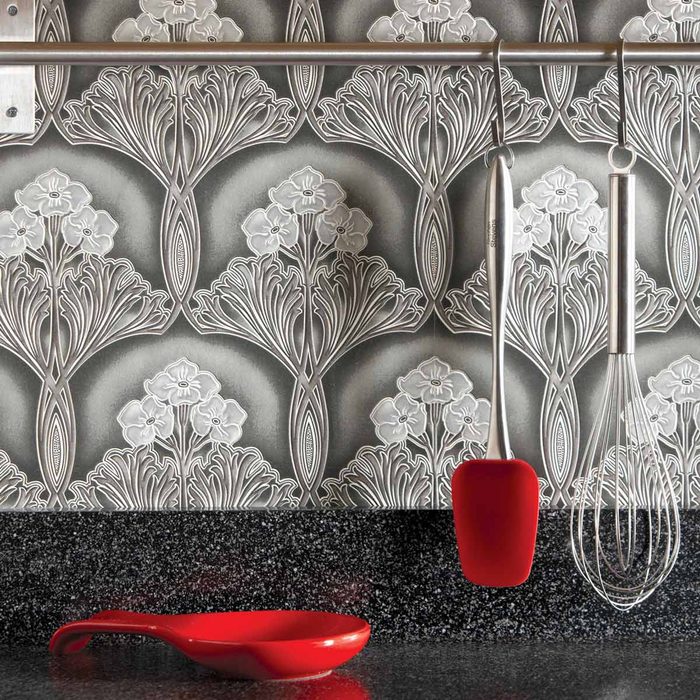 Kitchen with a grey, patterned wallpaper as its backsplash