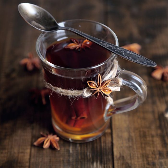 Apple cider vinegar in a glass with spoon and spices