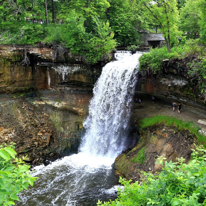 Tourists stand behind the Minnehaha Falls on the Minnehaha River, Minnehaha Park, Minneapolis, Hennepin County, Minnesota, Midwest, United States