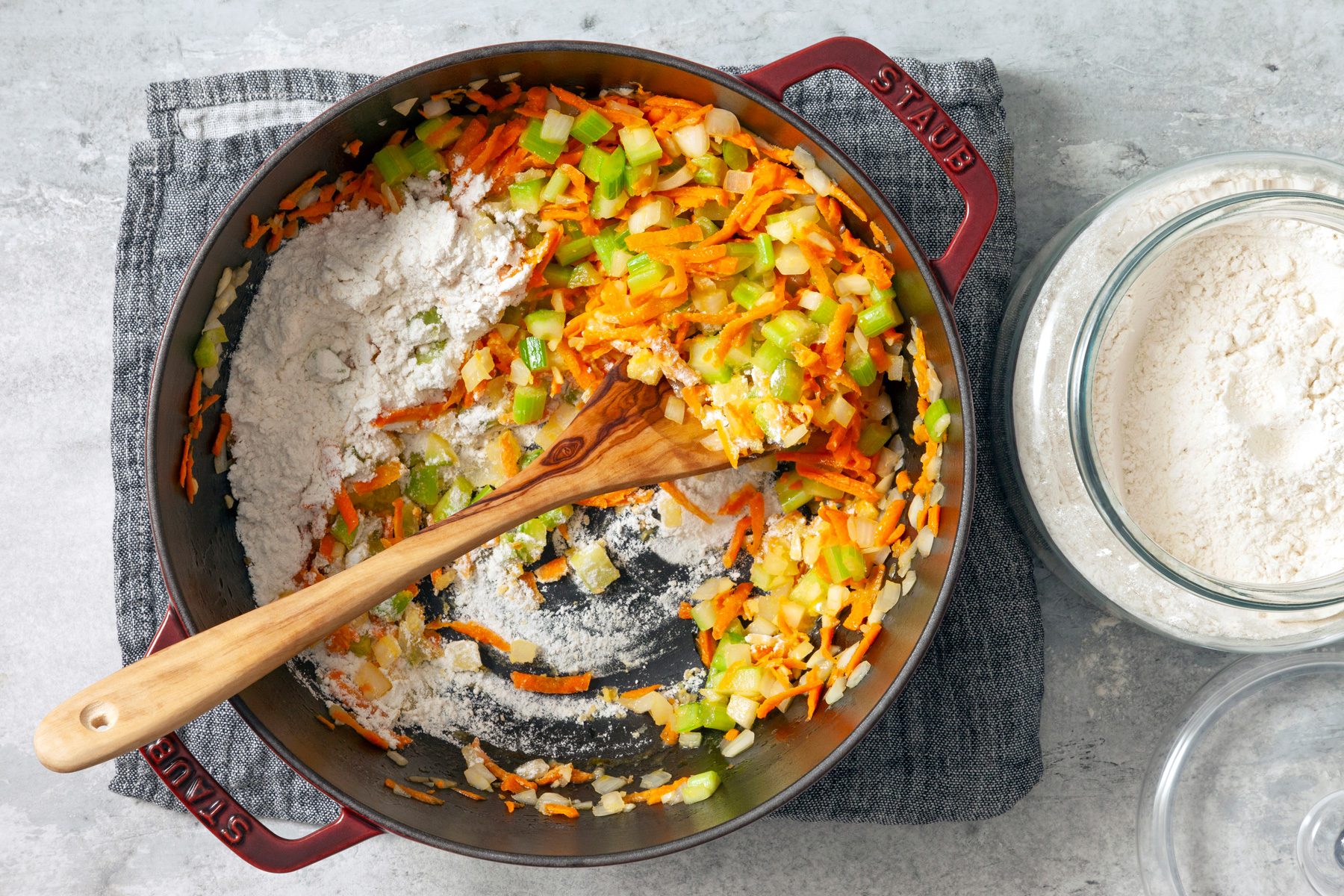 top view shot of adding flour to vegetable in pot 