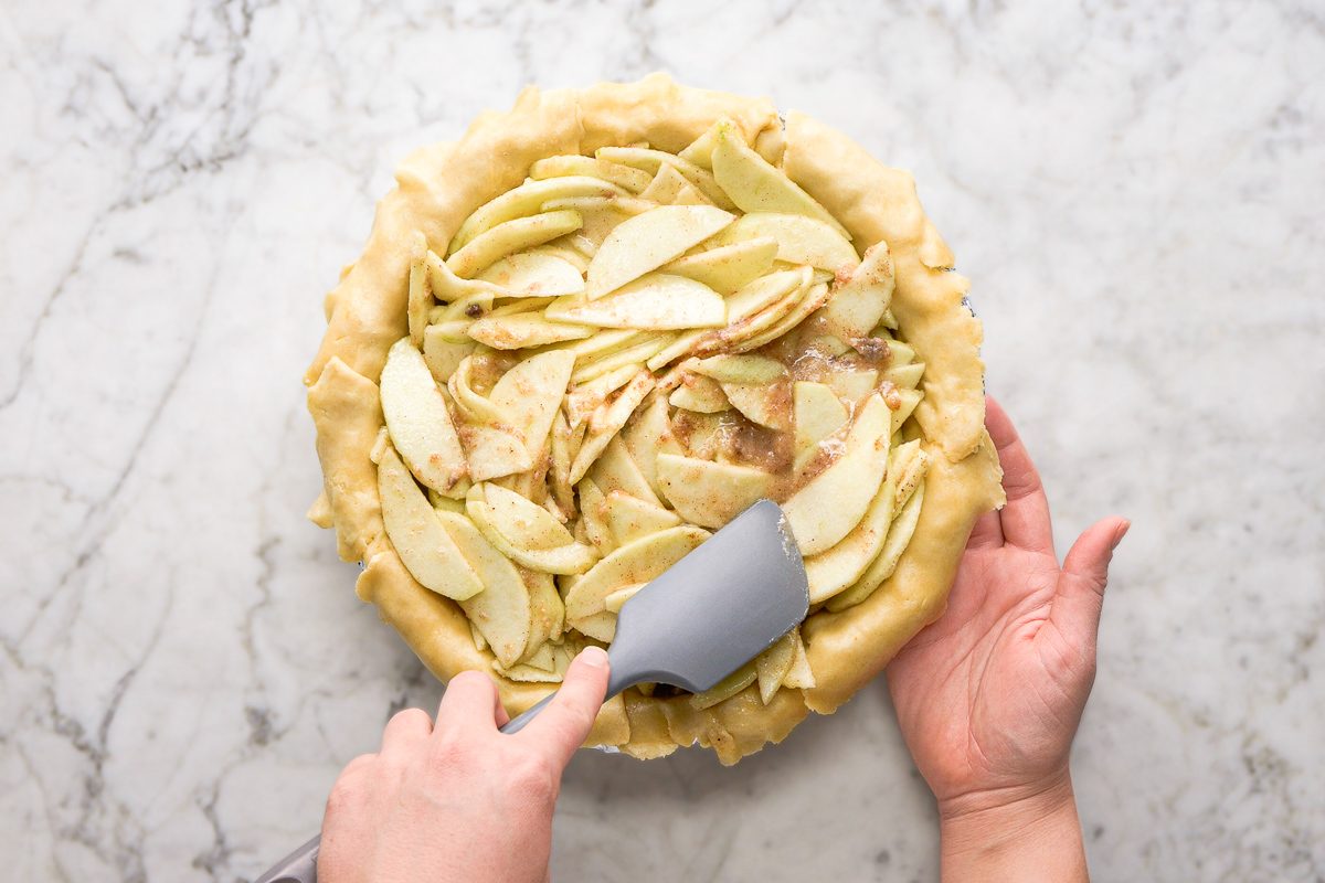 Pouring apple mixture into the pie shell